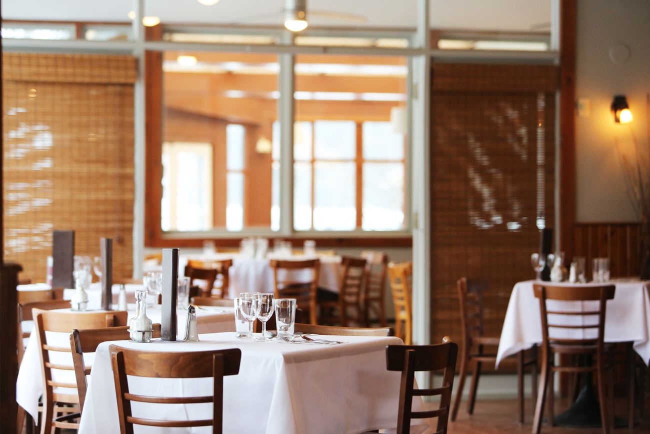 Inviting restaurant dining room with linen-covered tables and wooden chairs
